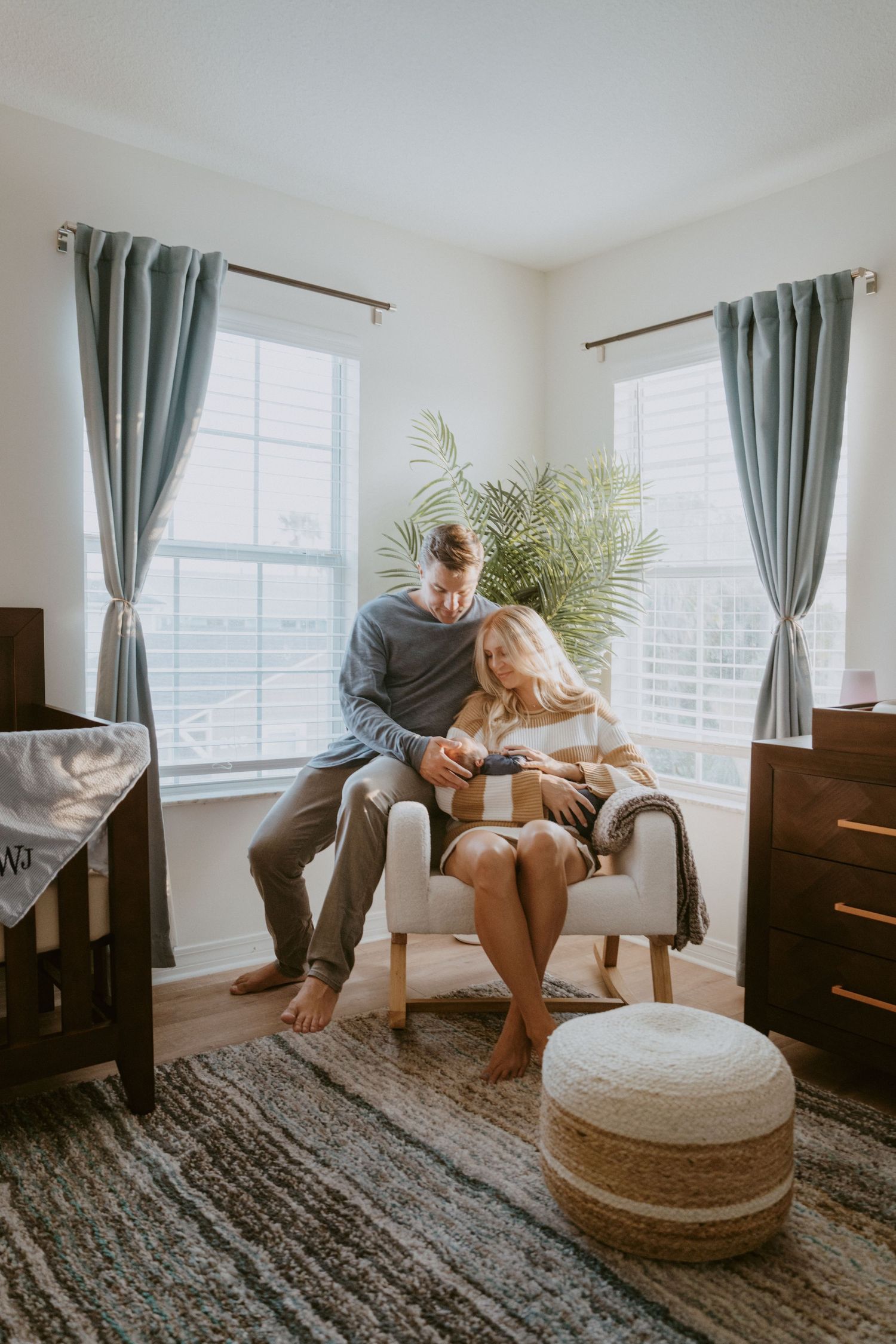 Couple relaxing together in comfortable armchair by window with natural light.