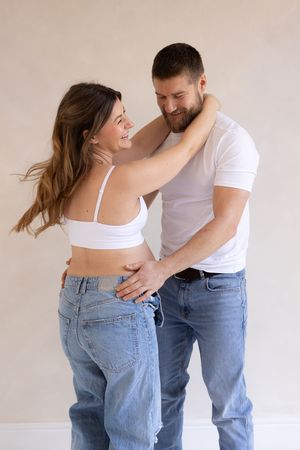 couple holding each other having fun during their maternity session based in Teeside studio
