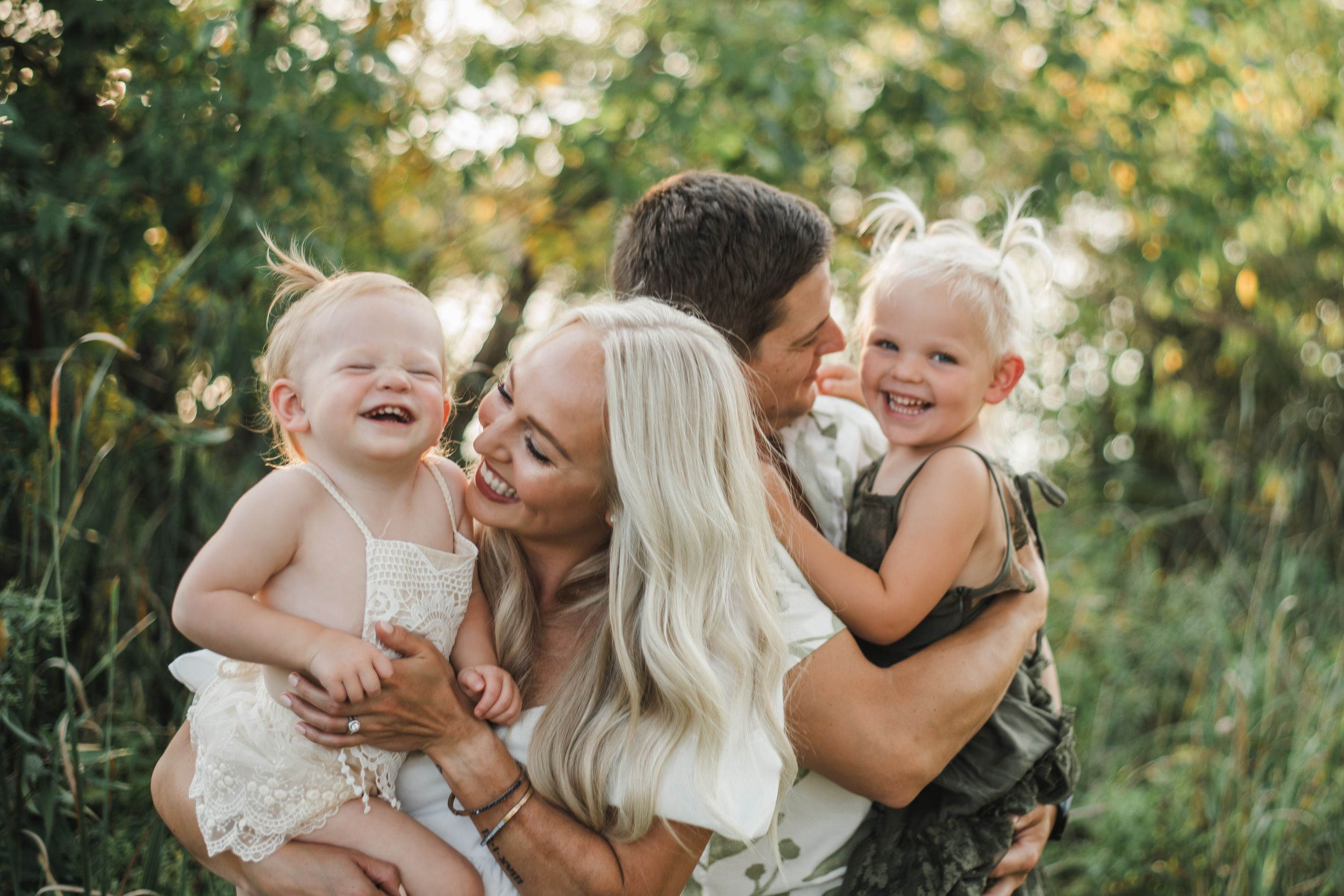 Family portrait session captured in golden hour sunlight among nature.