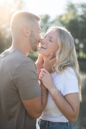 Intimate couple shares tender romantic moments in natural sunlit setting.
