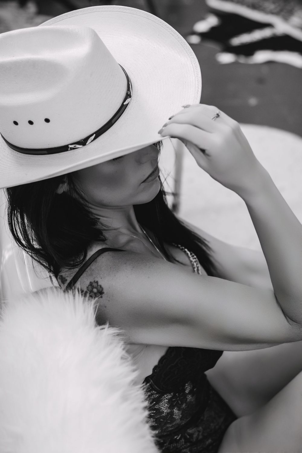 Western boudoir portrait of a confident woman topless with a cowboy hat, showcasing strength and femininity.