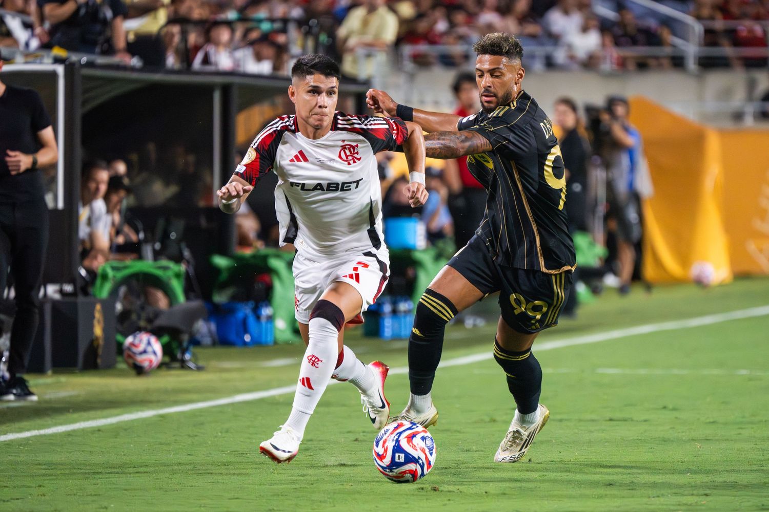 Soccer players compete for ball possession during an intense match on the field.
