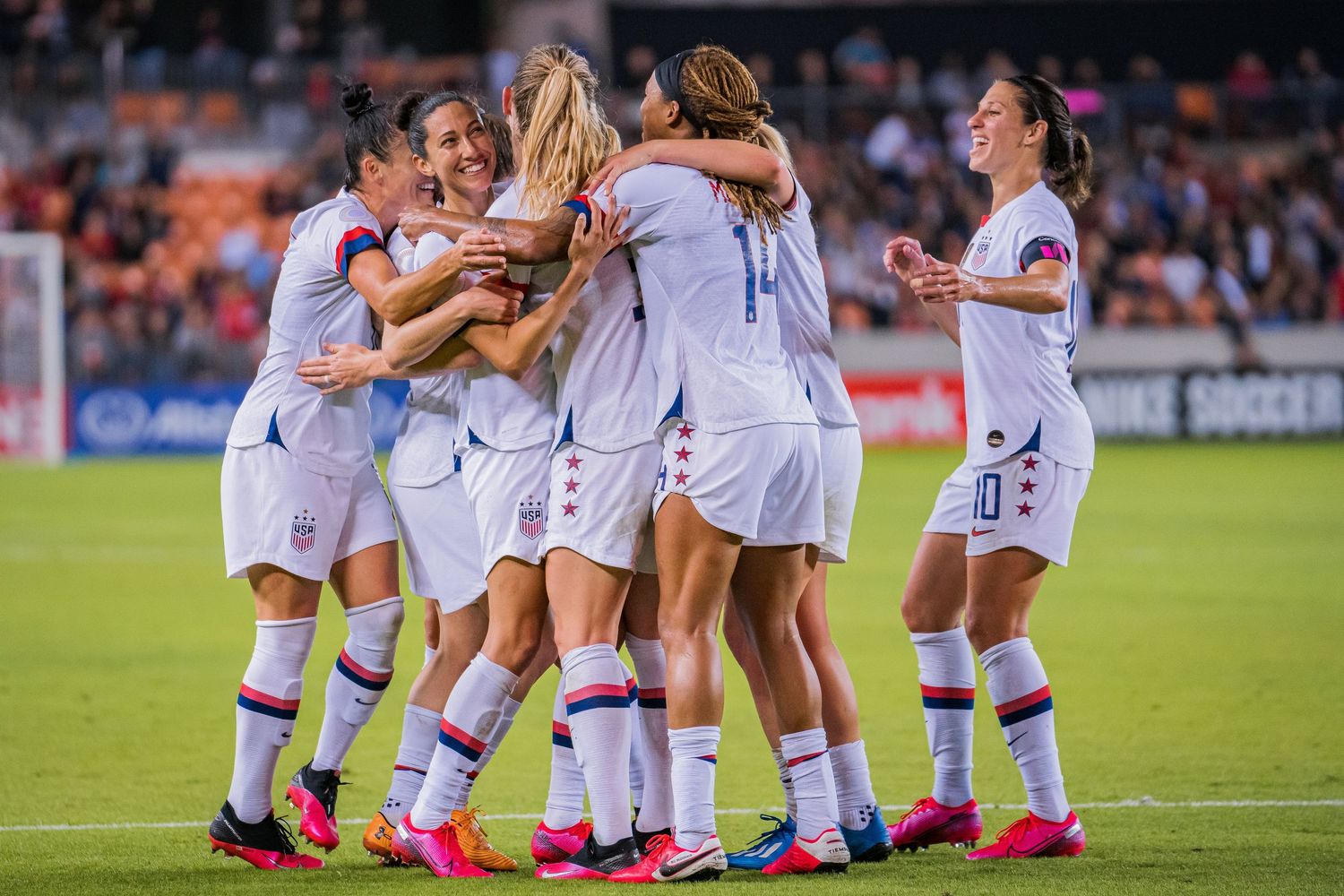 Soccer players celebrate together on the field after a victory in a competitive match.