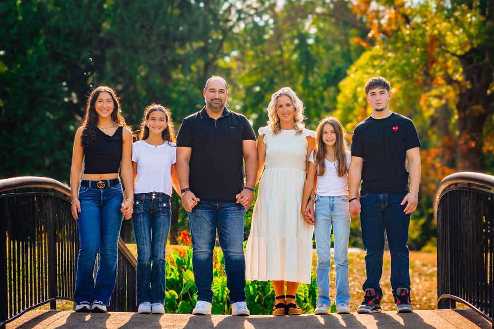 family portrait perfectly posed outdoors with colors abound and sunlight glow illuminating them