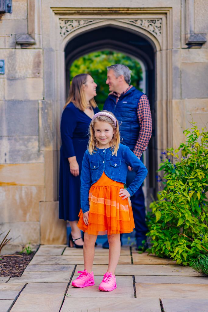 focus on young girl her parents behind her looking at each other