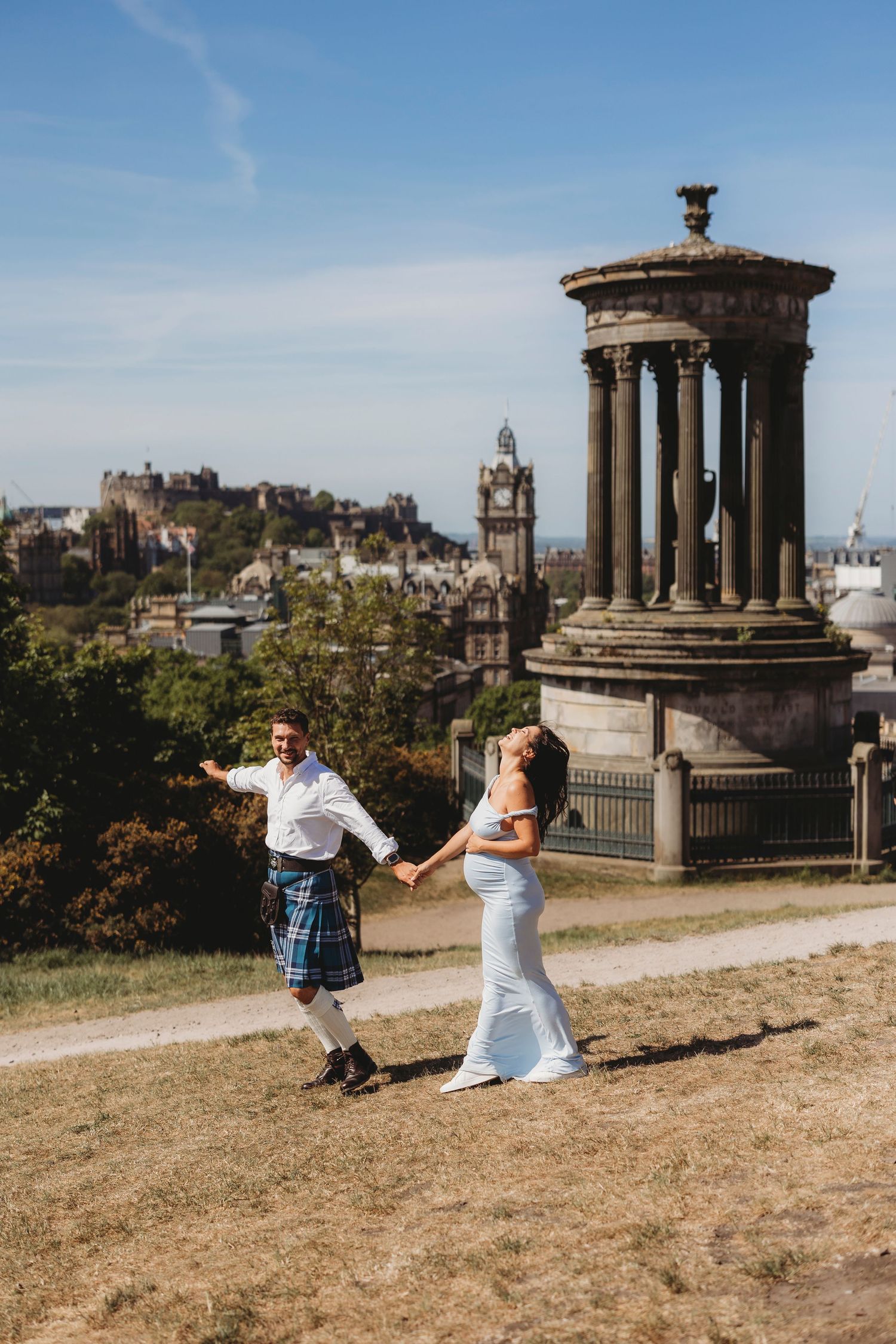 Elderly couple sharing tender moment on historic Edinburgh street.