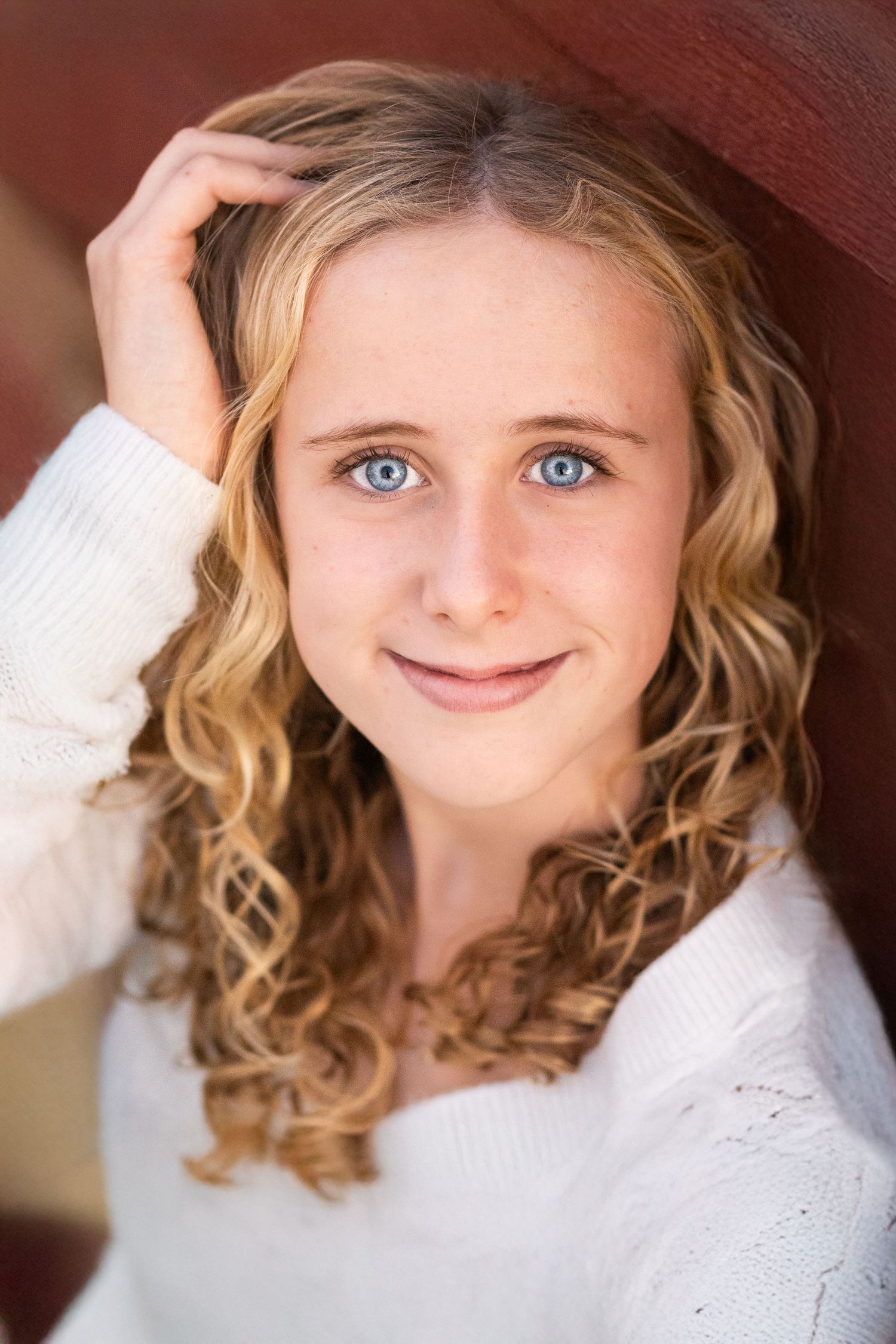 A series of five close-up portraits showing a young child with curly blonde hair and blue eyes wearing a white dress.