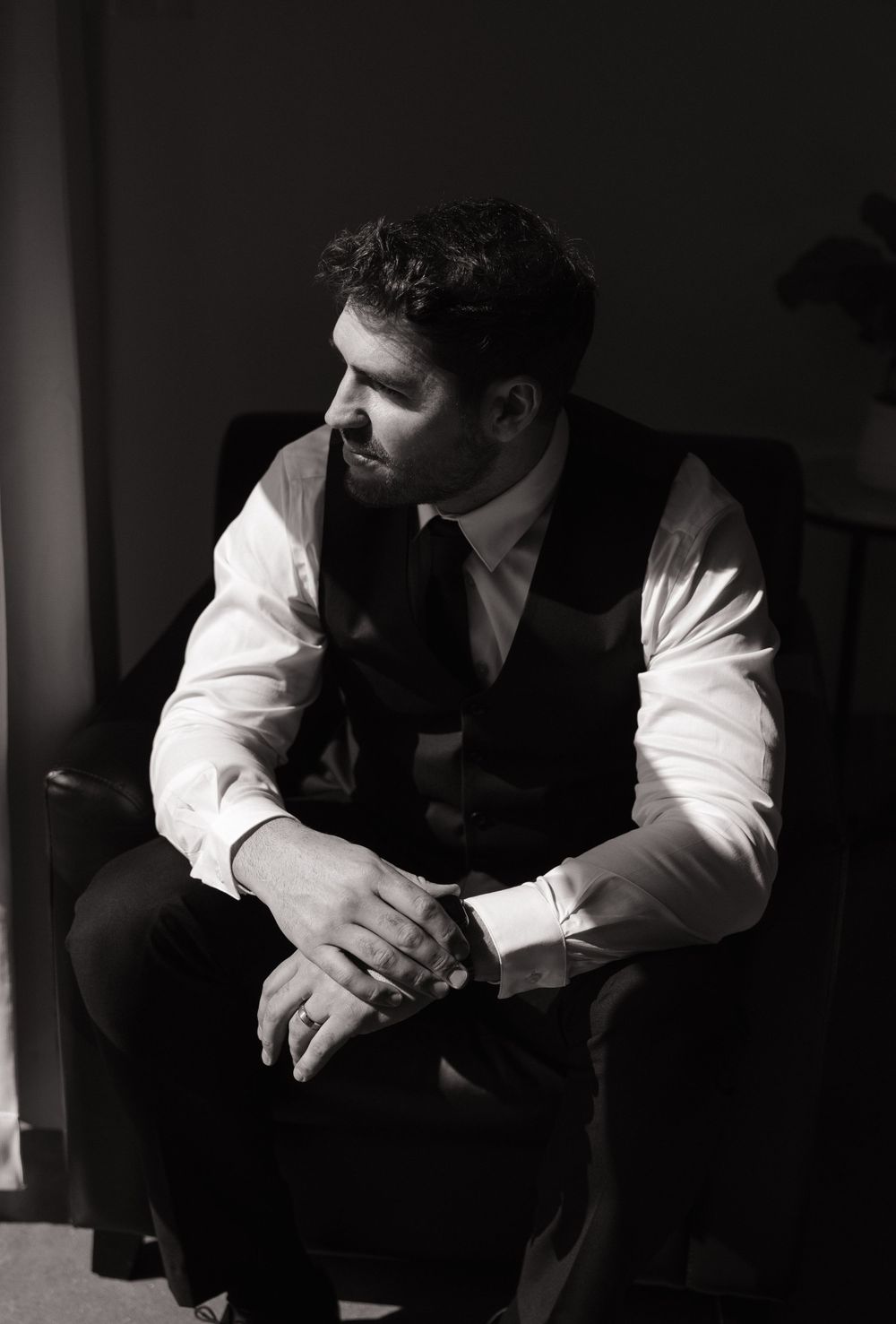 Classic black and white portrait of a groom in formal attire.