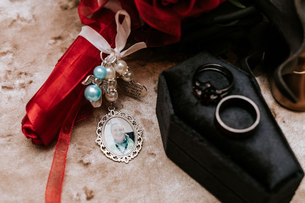 Vintage jewelry and accessories arranged artistically with red ribbons on a textured surface.