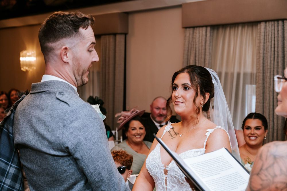 Wedding guests gather in a reception hall, smiling and celebrating with the newlyweds.