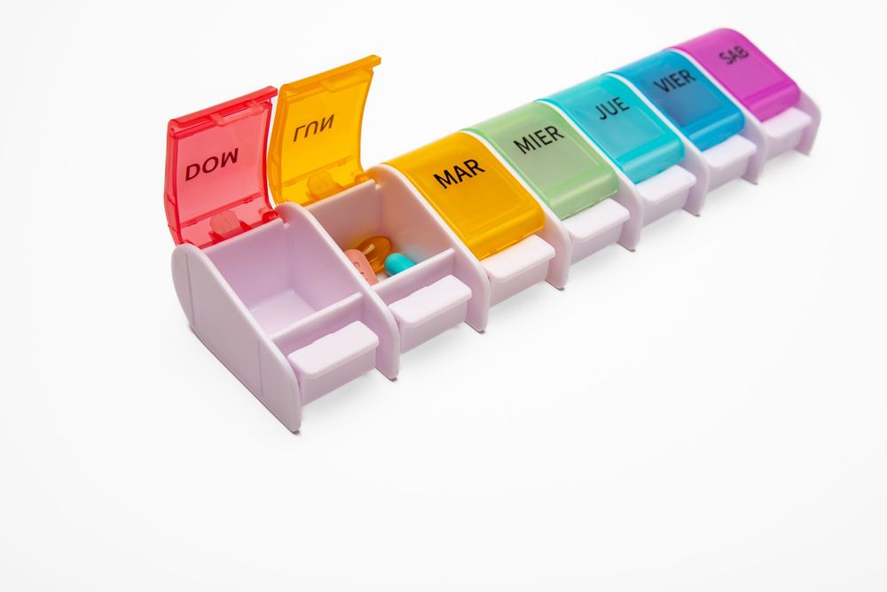 Product photo of a rainbow colored weekly pill organizer