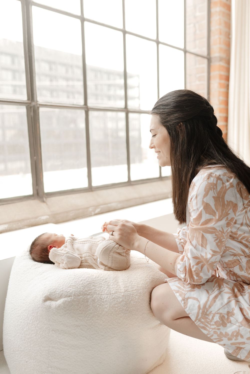 New mom playing with newborn baby at Toronto Newborn Photography session in a bright room by a window at Mint Room Studio, captured by Jess