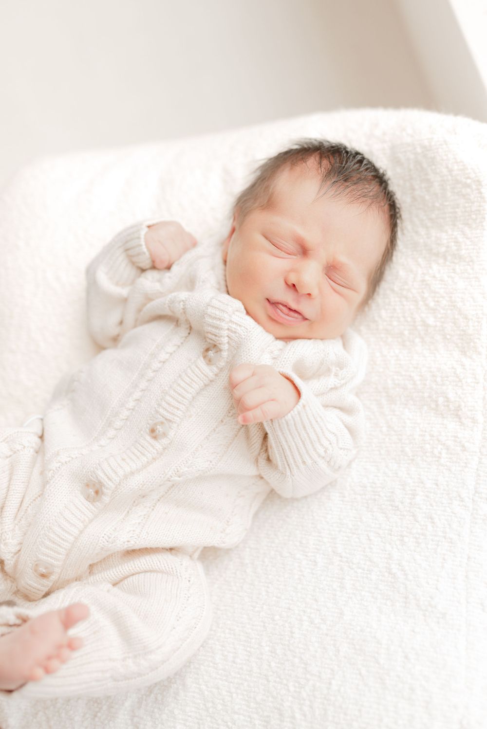 Newborn Baby wearing beige outfit in light and airy background for a toronto newborn photoshoot in Studio, at Mint Room Studios