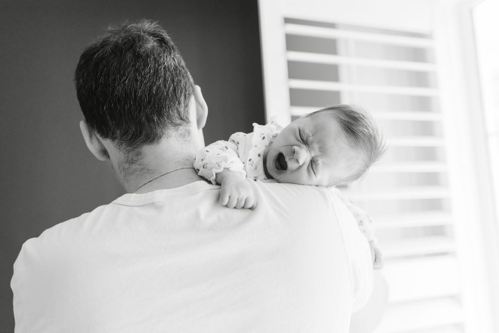 Yawning baby at a lifestyle in home newborn photoshoot in Toronto home, captured in black and white, natural newborn photography
