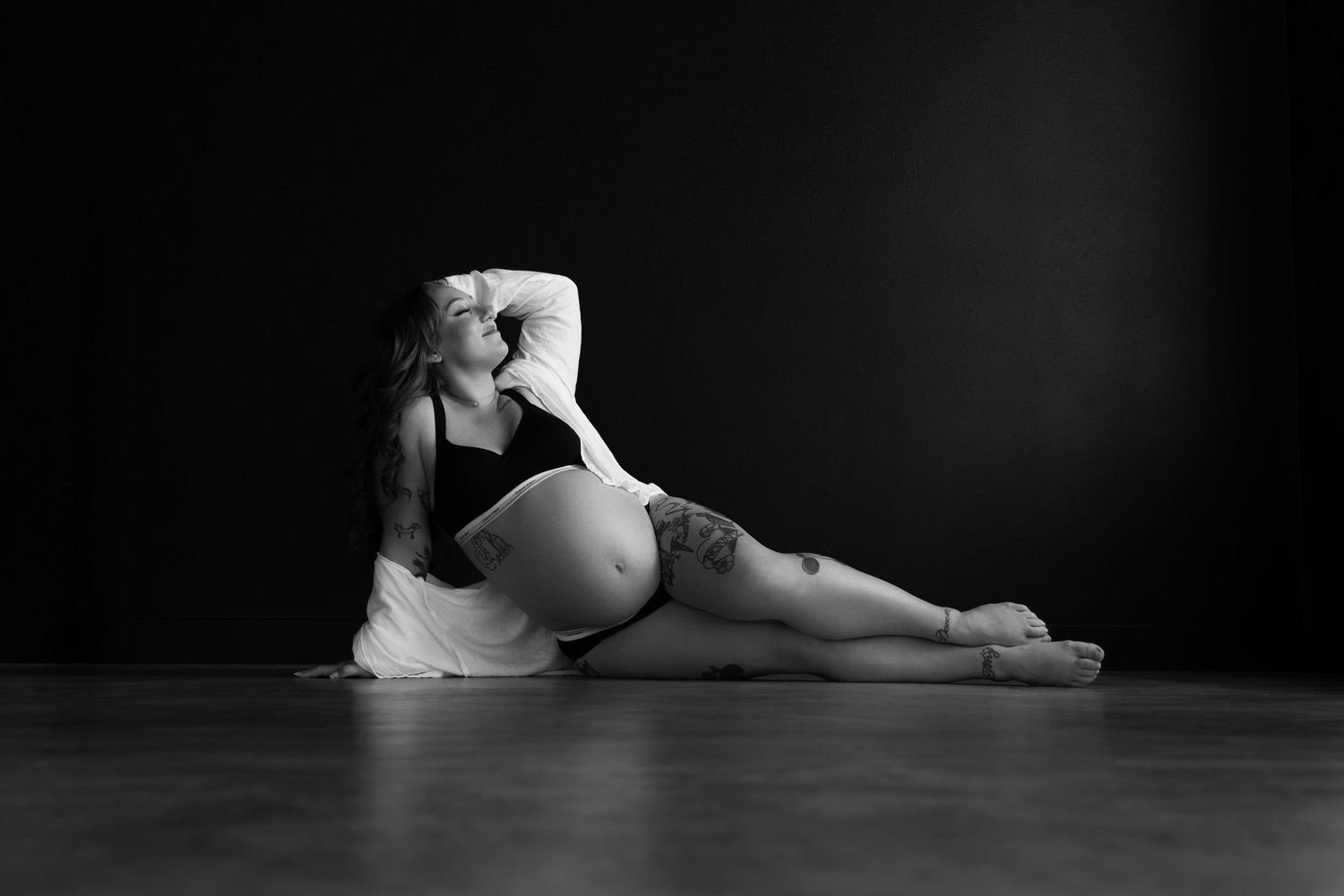 Pregnant woman embracing her body during a beautiful maternity boudoir session