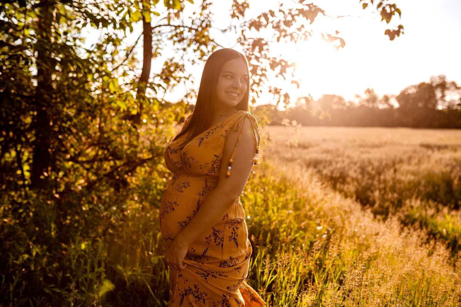 future maman dans un champs au golden hour