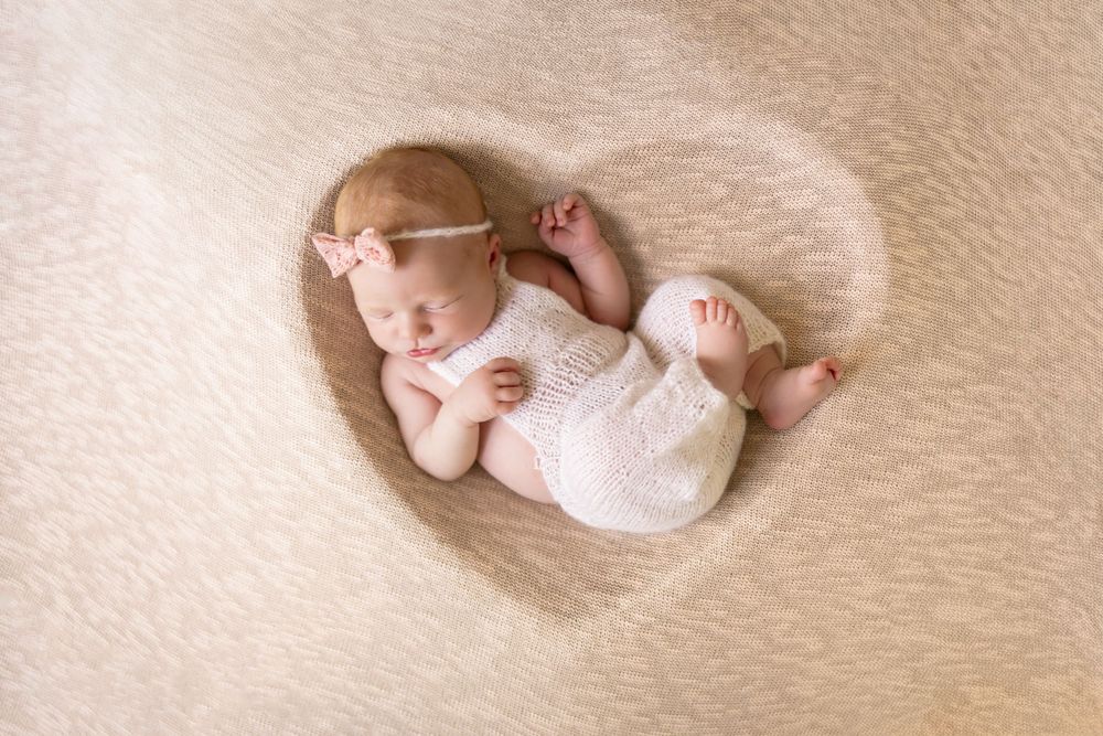 baby posed in a heart shaped bowl