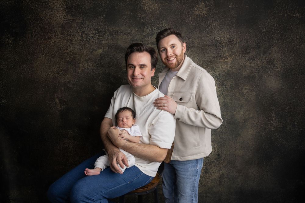 A series of five intimate black and white portraits showing tender moments between parents and their newborn baby.