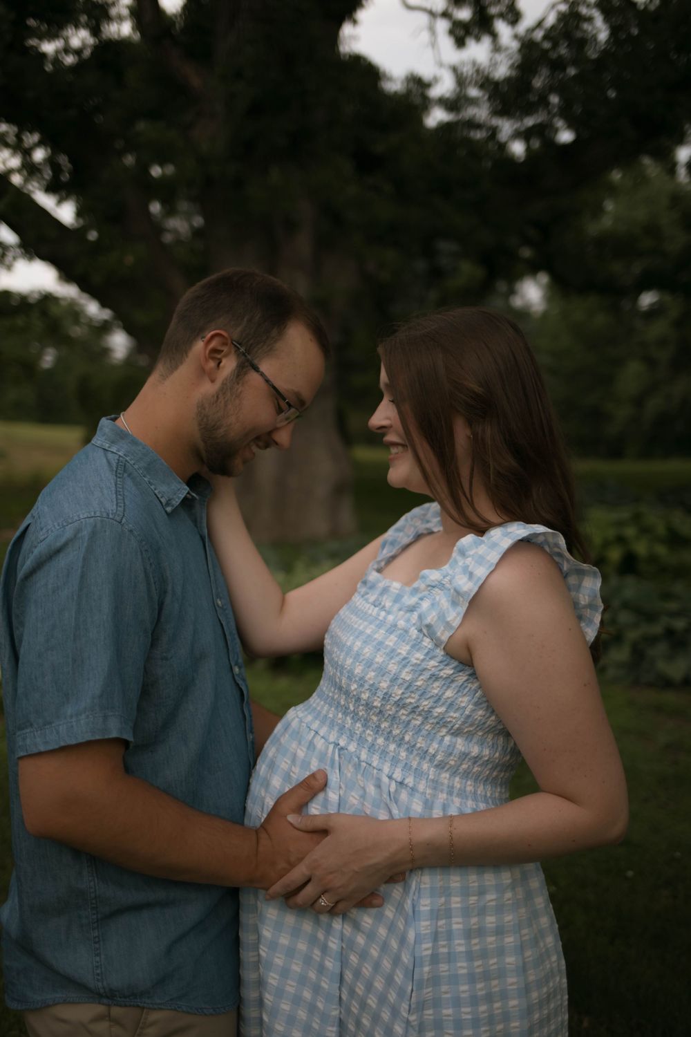 Intimate maternity session showing couple's tender moments outdoors.