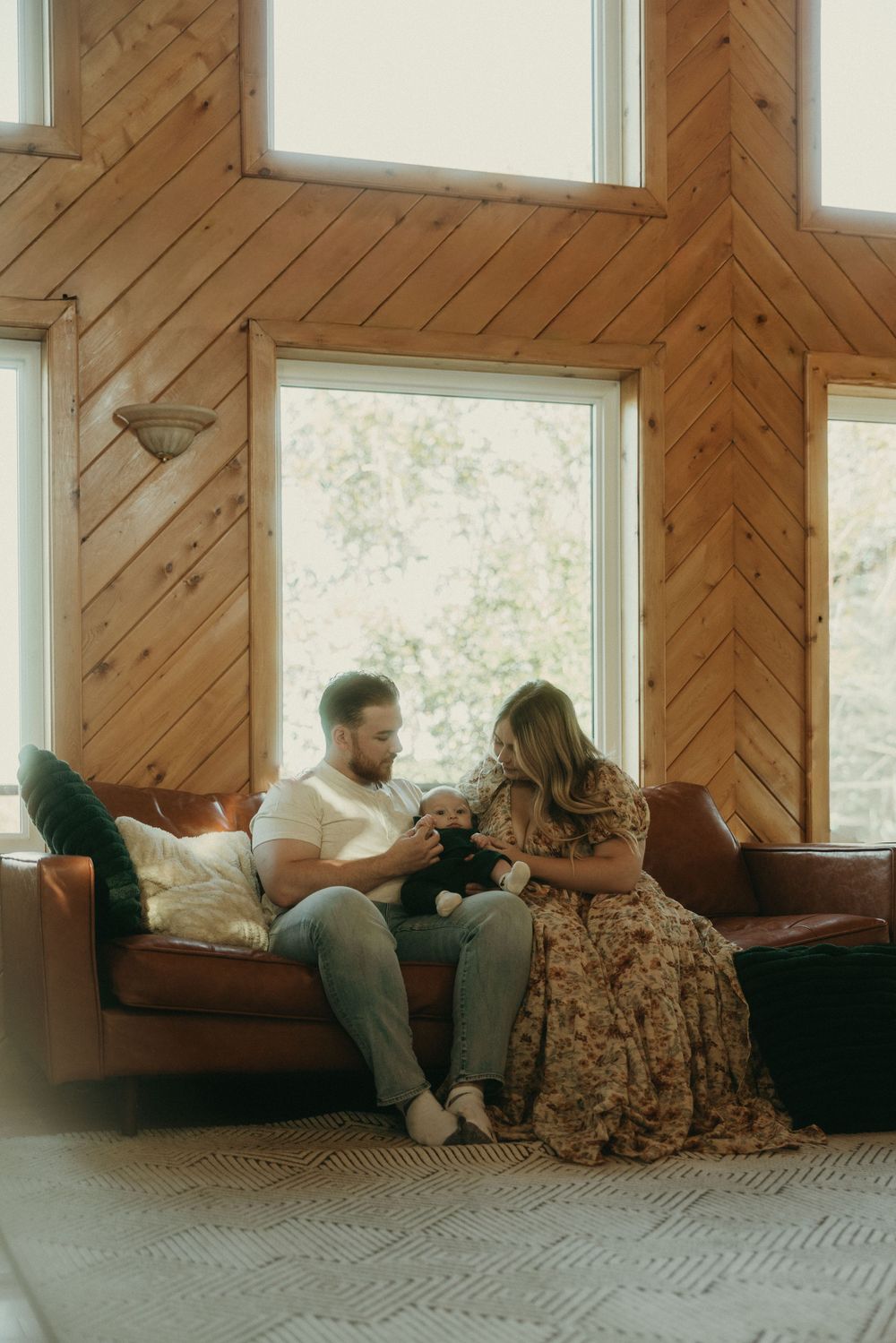 People relax together on a window seat with wooden chevron walls and natural lighting.