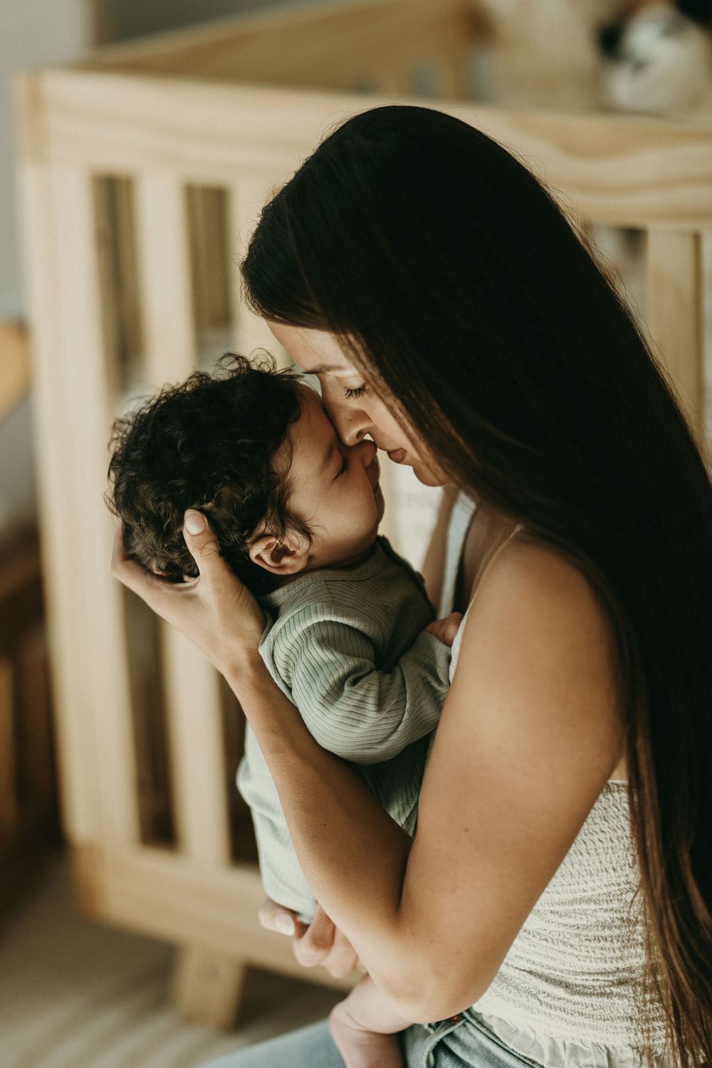 Intimate close-up portraits showing tender family moments with a baby in warm lighting.