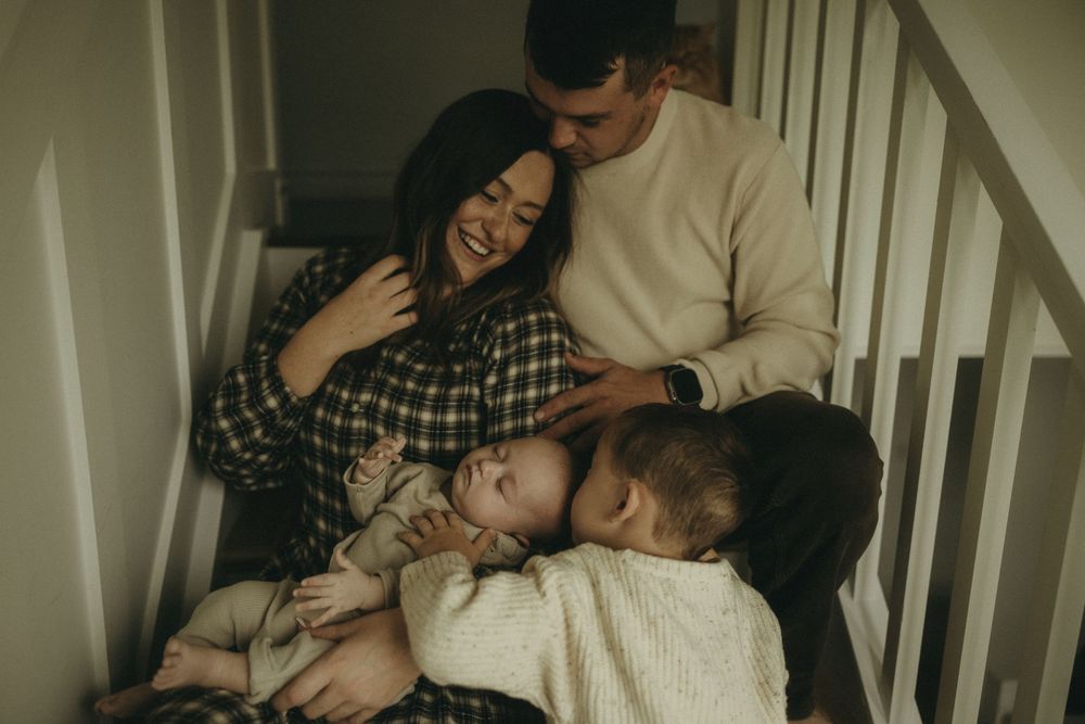 Joyful family moment captured on stairs in natural light.