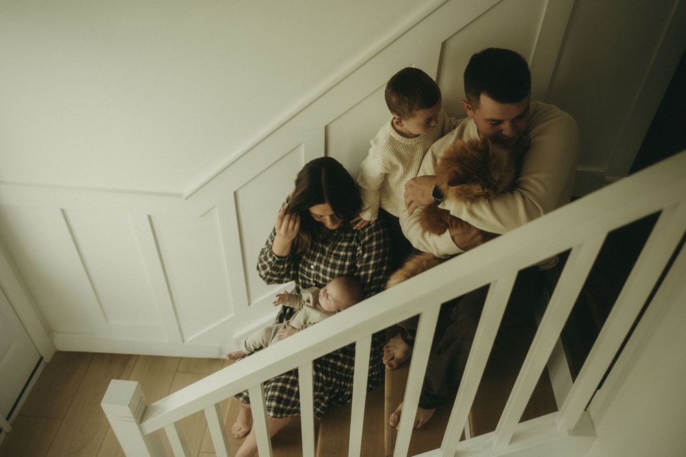 Family sitting together on white stairs viewed from above.