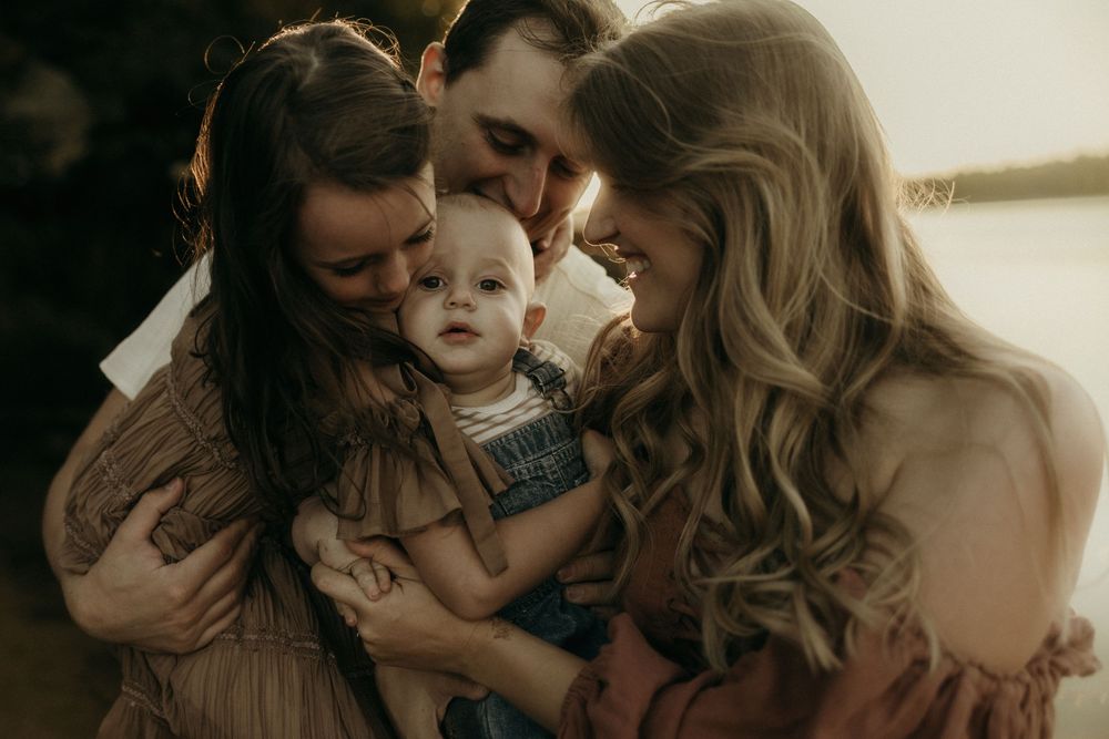 A tender family moment captured in warm sunset lighting.