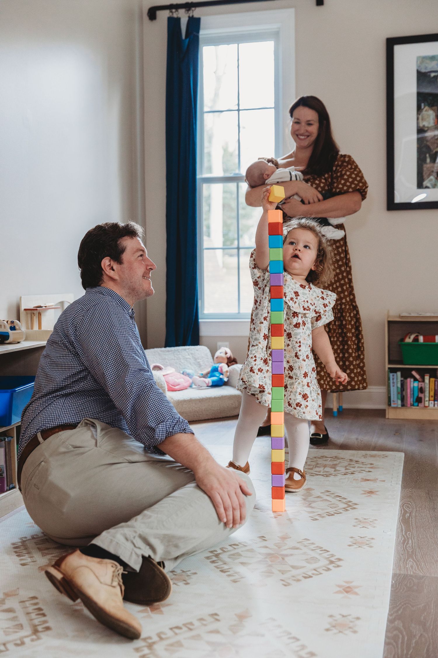 Playful indoor family photography sequence showing natural interactions on living room floor. Annapolis newborn photographer