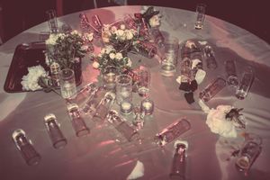 Elegant wedding reception table decorated with glowing candlelight, flowers, and crystal glassware creating a romantic ambiance.