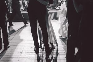 Black and white view of dancers' feet and legs on a dance floor at a formal event.