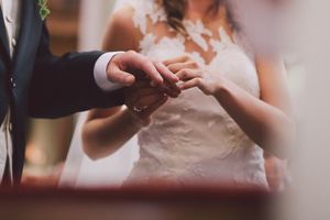 Close-up shot of hands exchanging wedding rings during a ceremony.