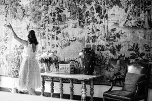 Black and white photo of vintage interior with floral wallpaper and antique furniture.