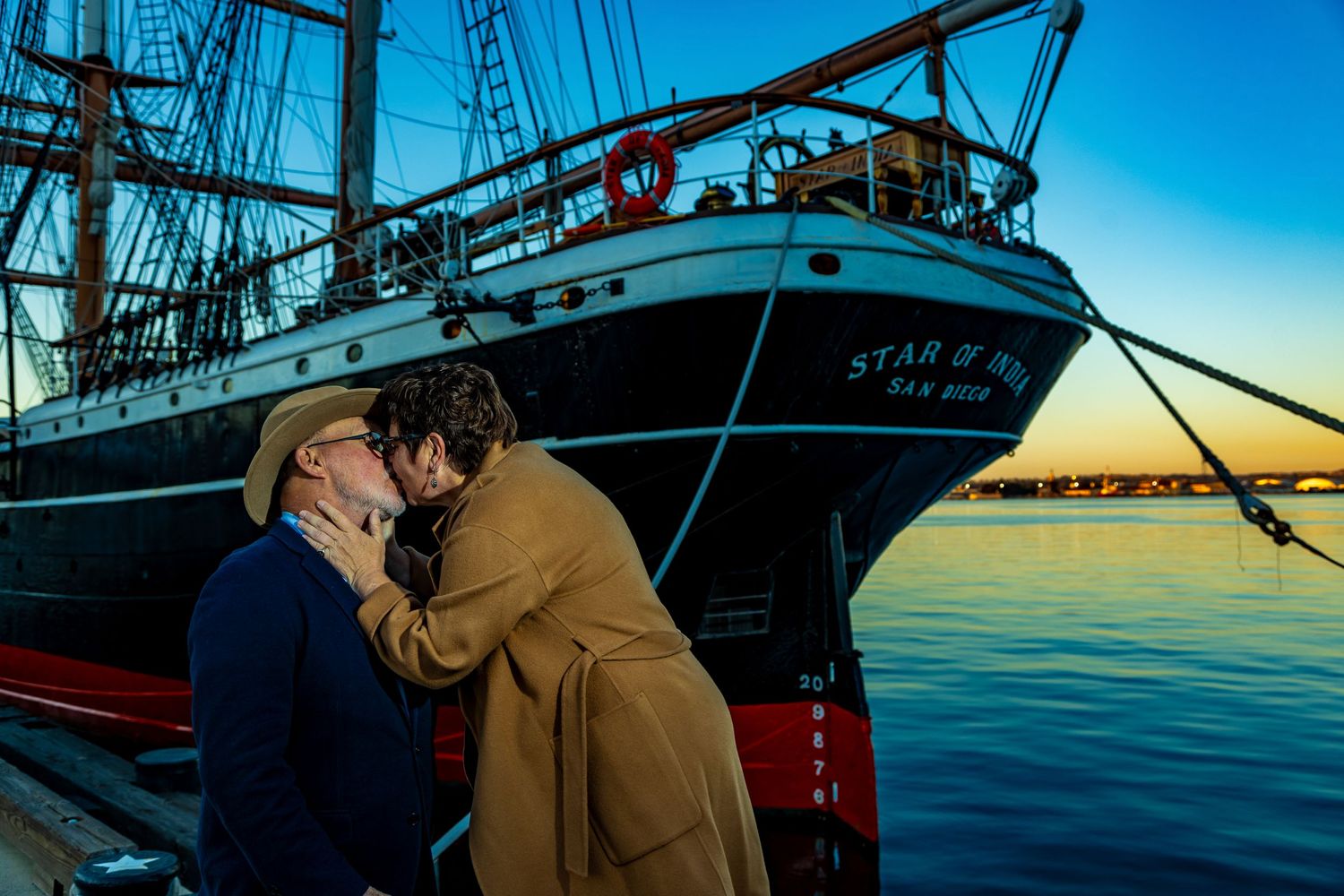 Tall sailing ship masts silhouetted against a blue sunset sky over calm waters.Shot By Zeus Holbrook San Diego Wedding Photographer