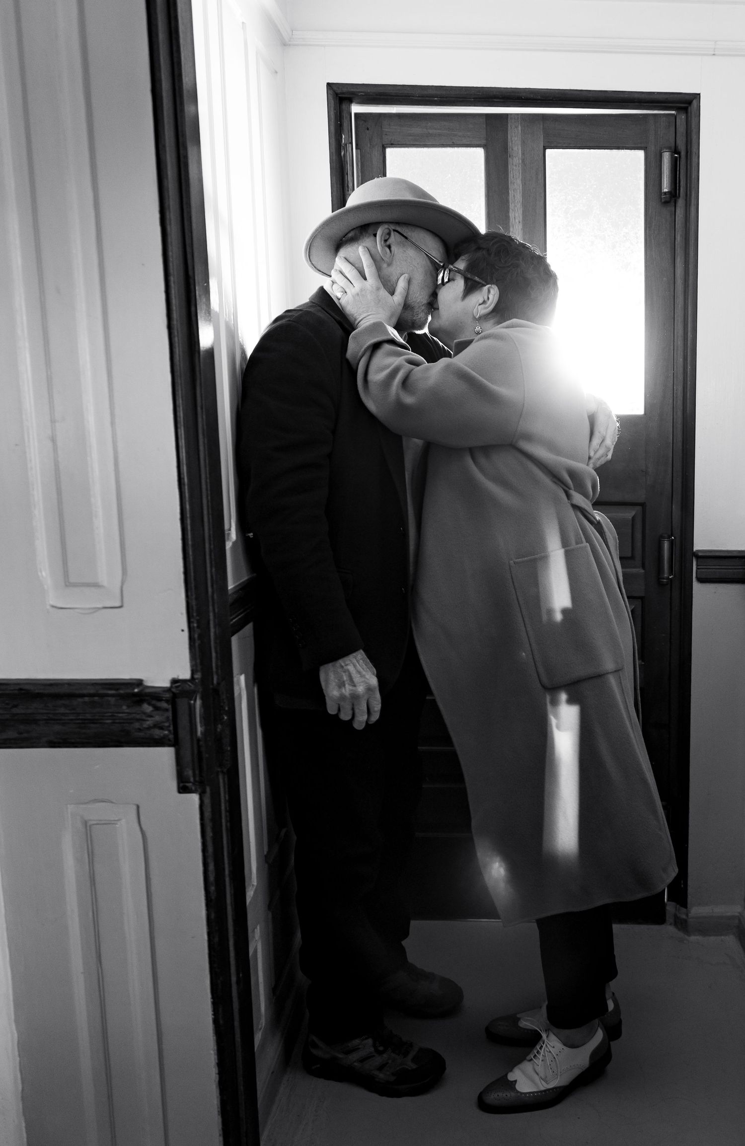A black and white sequence shows two people embracing in a hallway.Shot By Zeus Holbrook San Diego Wedding Photographer