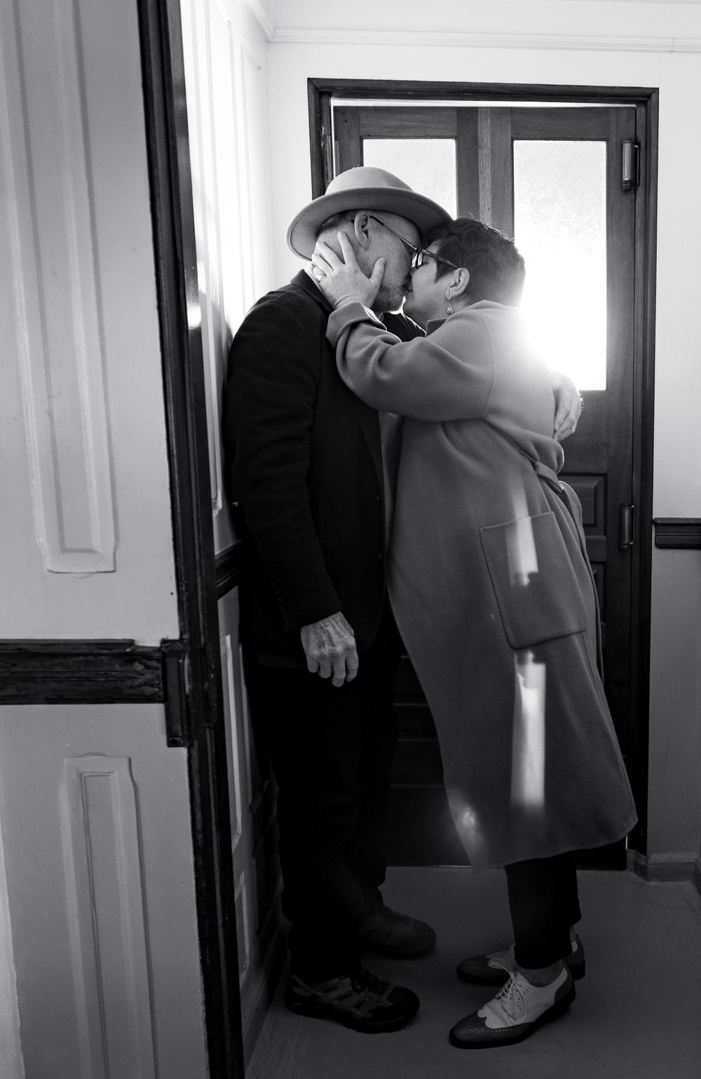 A black and white sequence shows two people embracing in a hallway.Shot By Zeus Holbrook San Diego Wedding Photographer