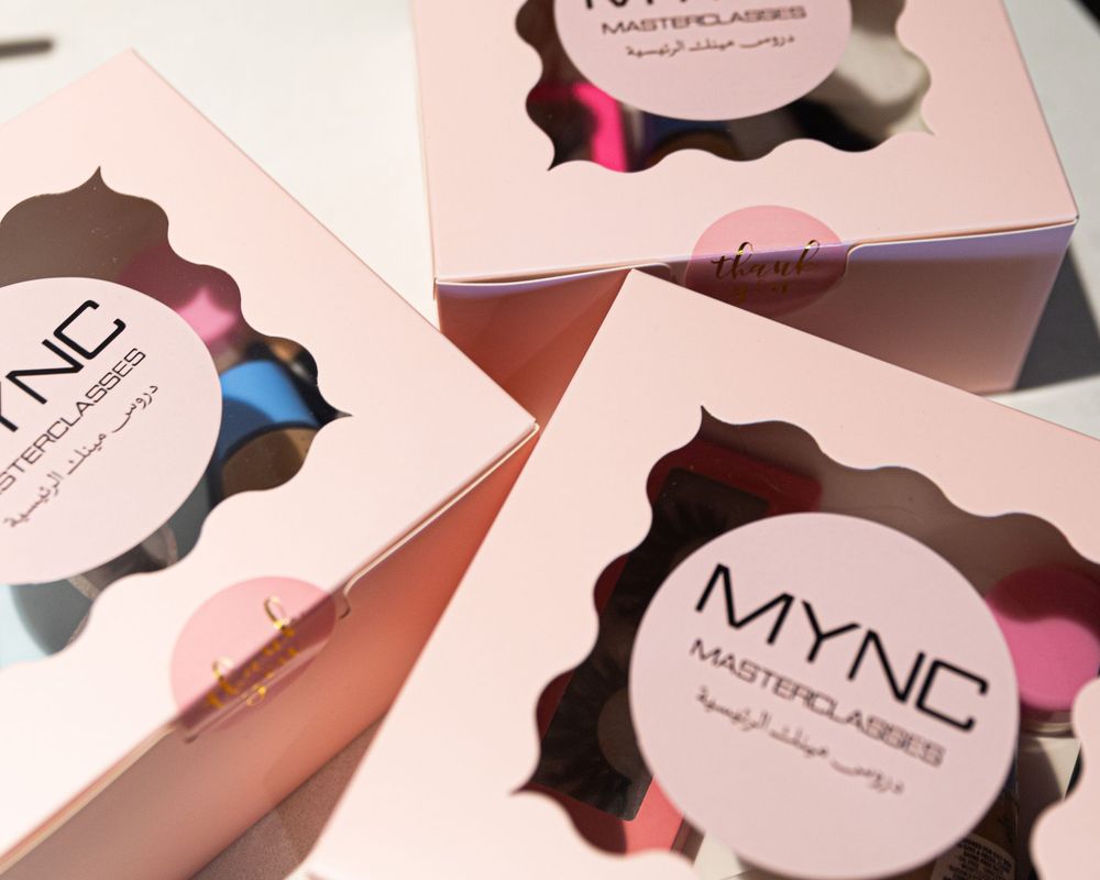 Three pink MYNC Masterclasses boxes with scalloped windows displaying colorful makeup sponges inside.