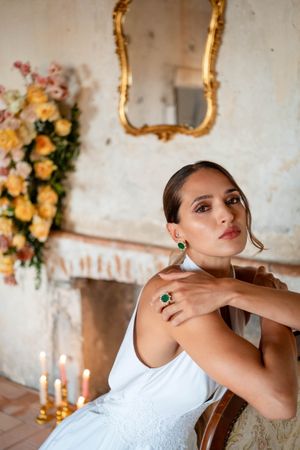 Bridal portrait session featuring white dress and elegant jewelry in vintage-style setting.