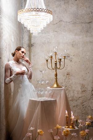 Elegant bridal portrait under crystal chandelier with vintage gold candelabra and candlelight.