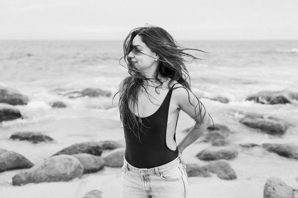 Wind-swept moment captured in black and white on rocky beach.