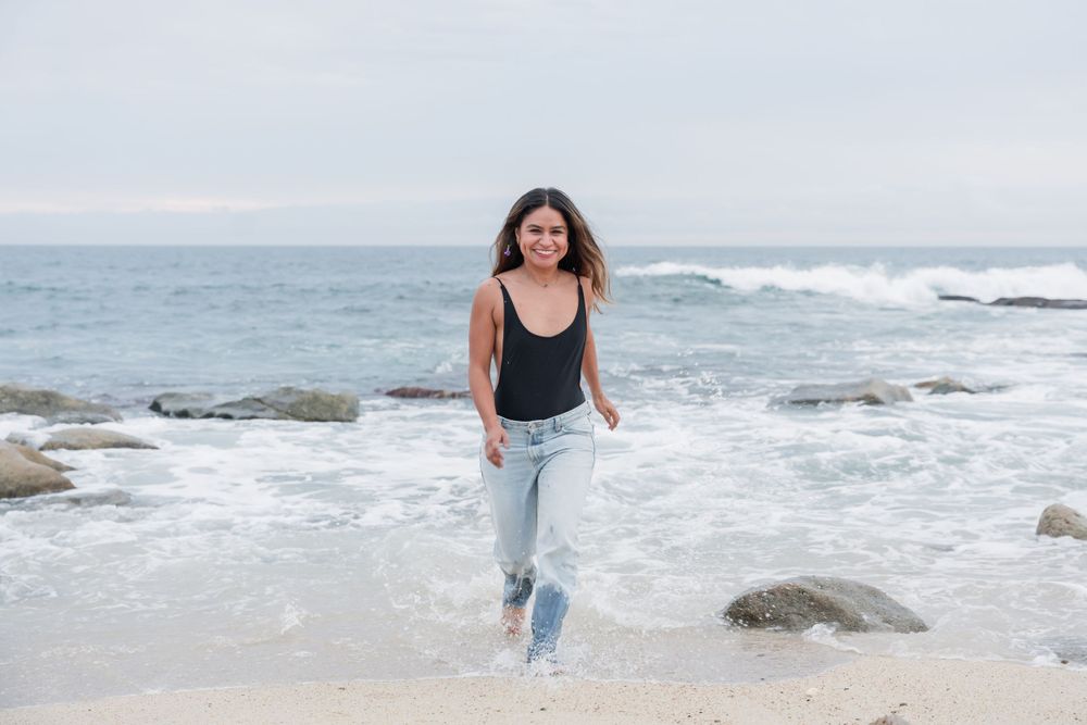 Casual beachside photo with crashing waves on rocky shore. Cabo