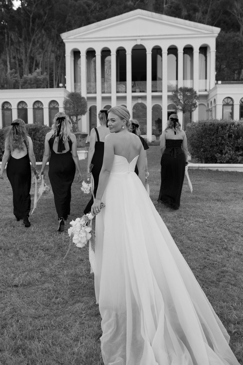 Bride looking back, behind her bridal party at Manor House at La Roche Estate.