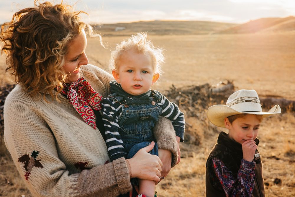 A family enjoys a golden sunset moment in an arid landscape during a warm evening outdoors.