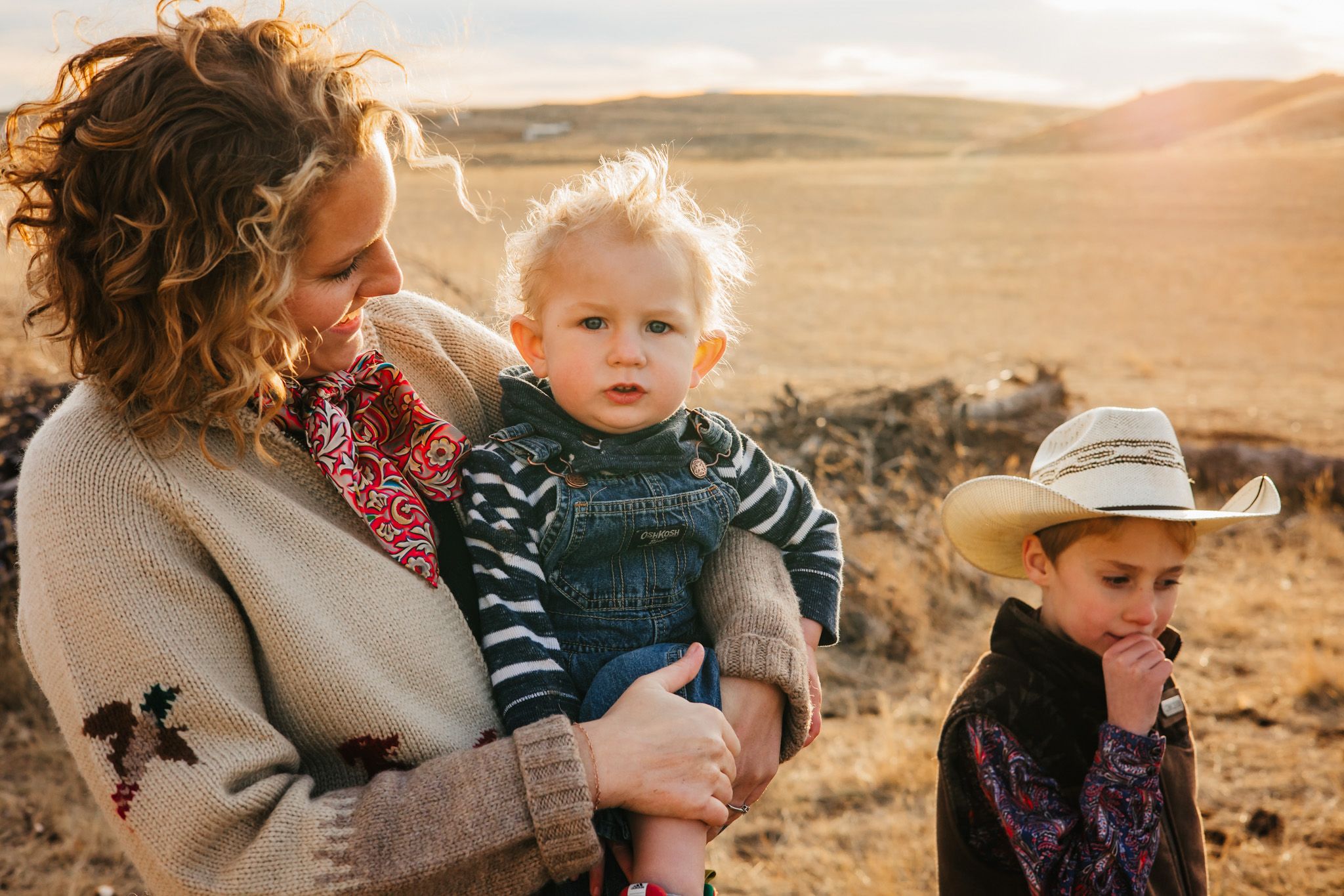 A family enjoys a golden sunset moment in an arid landscape during a warm evening outdoors.