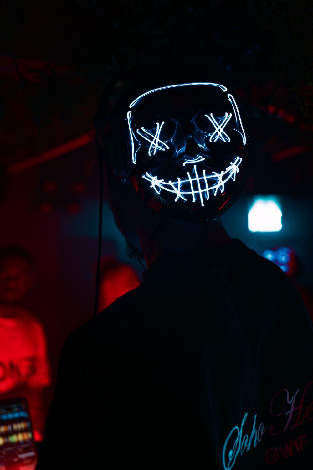 Glowing neon blue LED mask creates an eerie atmosphere against dark background in a sequence of photos.