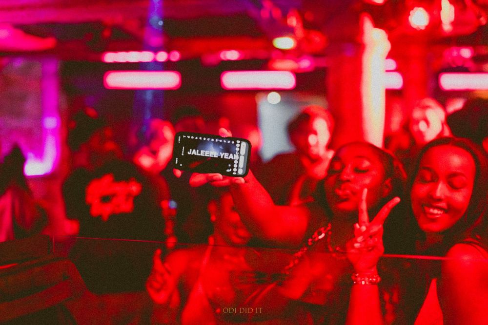 Concert crowd illuminated in vibrant red lighting during a live music performance at a nightclub venue.