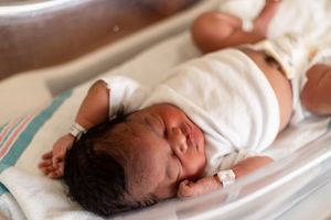 A series of medical photos showing a newborn baby being examined on an examination table.