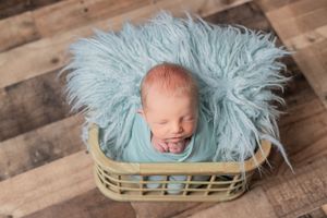 Newborn photography collage showing baby sleeping in blue fur blanket on rustic wooden backdrop.