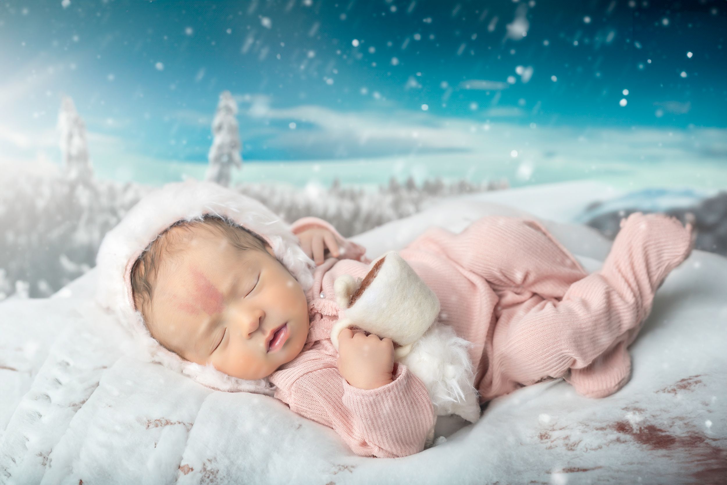 Peaceful winter scene with sleeping infant in pink against snowy background.