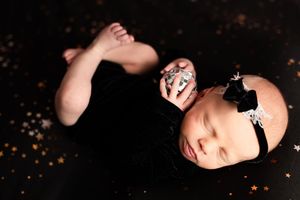 A series of artistic black and white portrait photos showing a person against a dark background with scattered glitter effects.